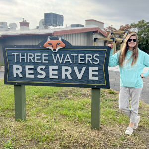 Swann next to the Three Rivers Reserve sign, SWLC’s flagship nature reserve. Photo courtesy of Aran Swann