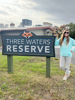 Swann next to the Three Rivers Reserve sign, SWLC’s flagship nature reserve. Photo courtesy of Aran Swann