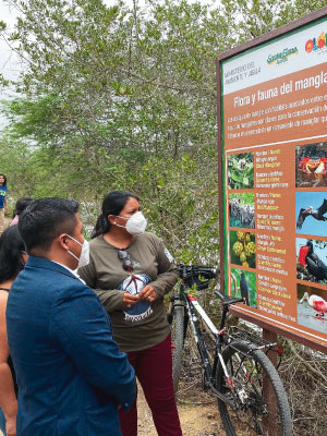 Toapanta is shown with the flora and fauna sign at Olón community, which was created to bring more tourism to the local Mangrove. Photo credit: Joffre Ibarra