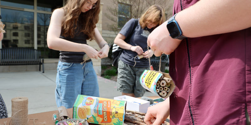Students creating bee hotels during Earth Fest event.