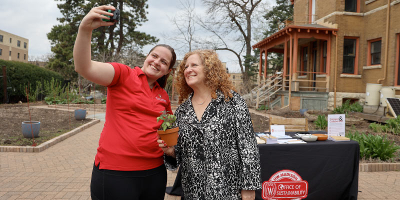 Selfies at the plant swap event with a student and Chancellor Jennifer L. Mnookin.