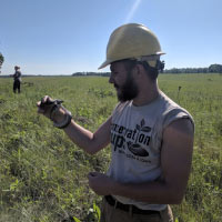 Meeker holding a bull snake while performing a snake survey with the Minnesota Conservation Corps.
