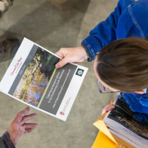 Abby Becker, senior associate for communications and outreach with UniverCity Alliance, hands out a informational materials during an educational event for the Koshkonong Creek Watershed held at Badger Farms in Deerfield, Wisconsin. Photos by Bryce Richter / UW–Madison