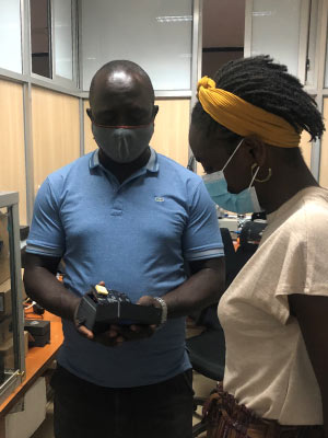 Dorothy Lsoto at the Airqo lab at Makerere University with Joel, one of the airqo engineers. Joel shared how the low-cost air quality sensors work, and the step-by-step production process of how they make the air quality monitors in their lab. Photo credit: Deo, assistant engineer.