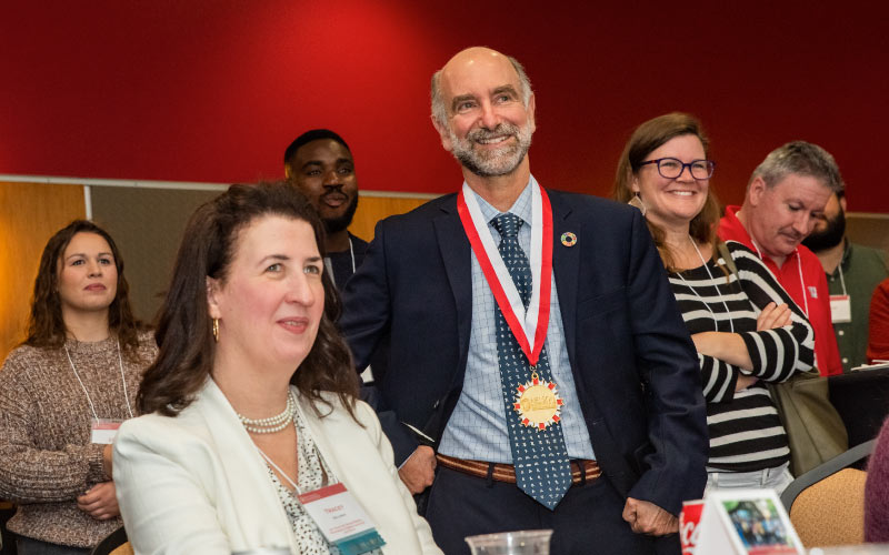 Tracey Holloway (seated), inaugural Jeff Rudd and Jeanne Bissell Professor of Energy Analysis and Policy, and Jonathan Patz (center) listen to remarks from each of the alumni award winners in attendance. Photo credit: Ingrid Laas