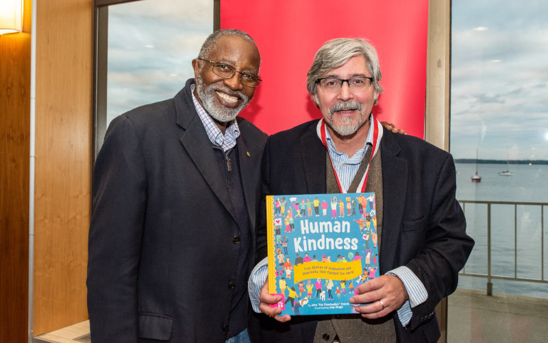 Nelson alumnus John Francis (left) shares a copy of his new childrens’ book, Human Kindness, with Paul Robbins. Photo credit: Ingrid Laas