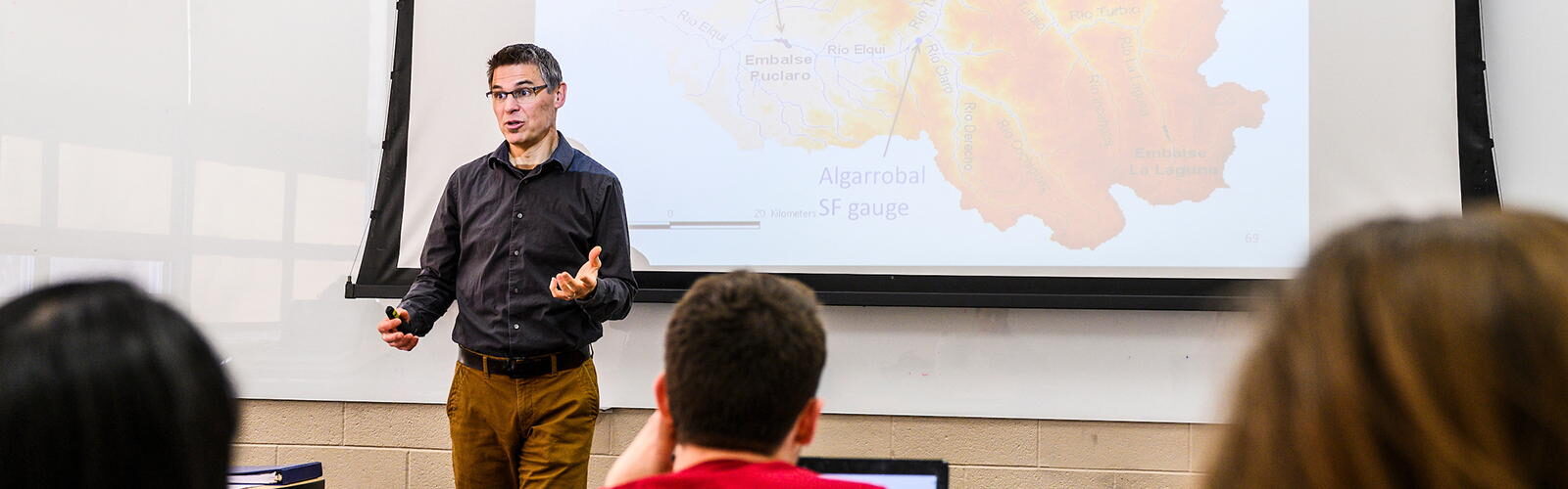 Paul Block in a classroom, standing in front of a map, teaching Hydroclimatology for Water Resources Management