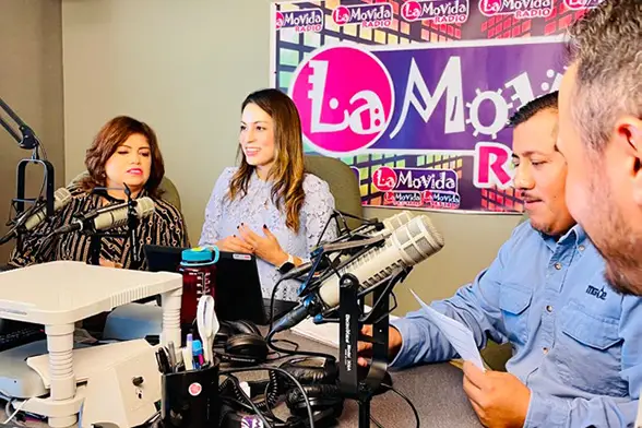 Gloria Castillo Posada speaking in a radio station studio