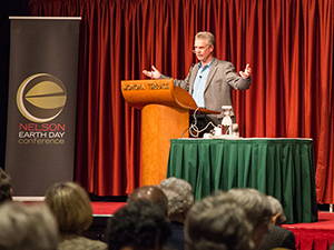 A person speaking at a podium during an Earth Day conference