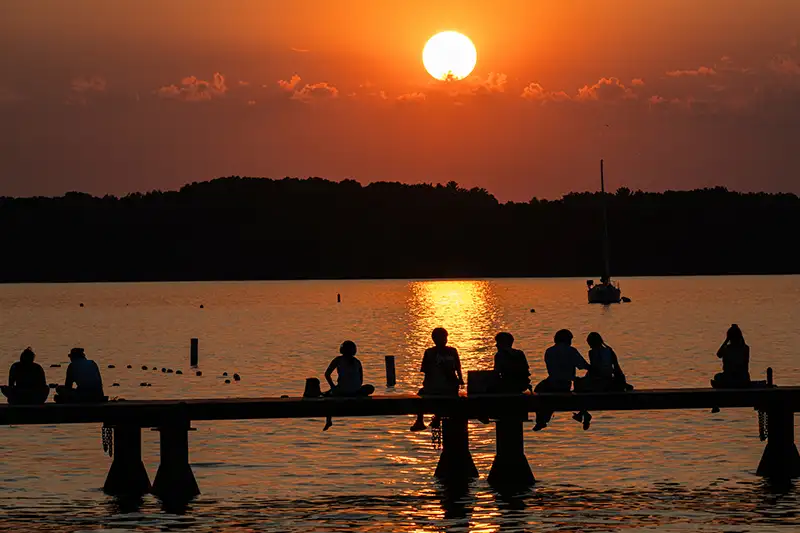 Several students gather at Goodspeed Pier at sunset.