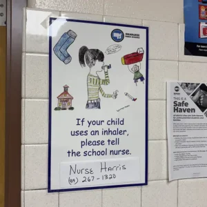 Sign in a school room with instructions to contact the school nurse if a child uses an inhaler.