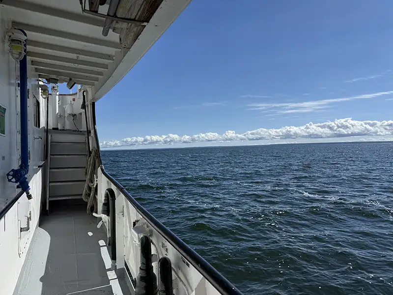 Looking out from the deck of a research vessel at an open body of water.