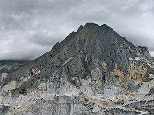 Long-distance view of a mountain against a cloudy sky