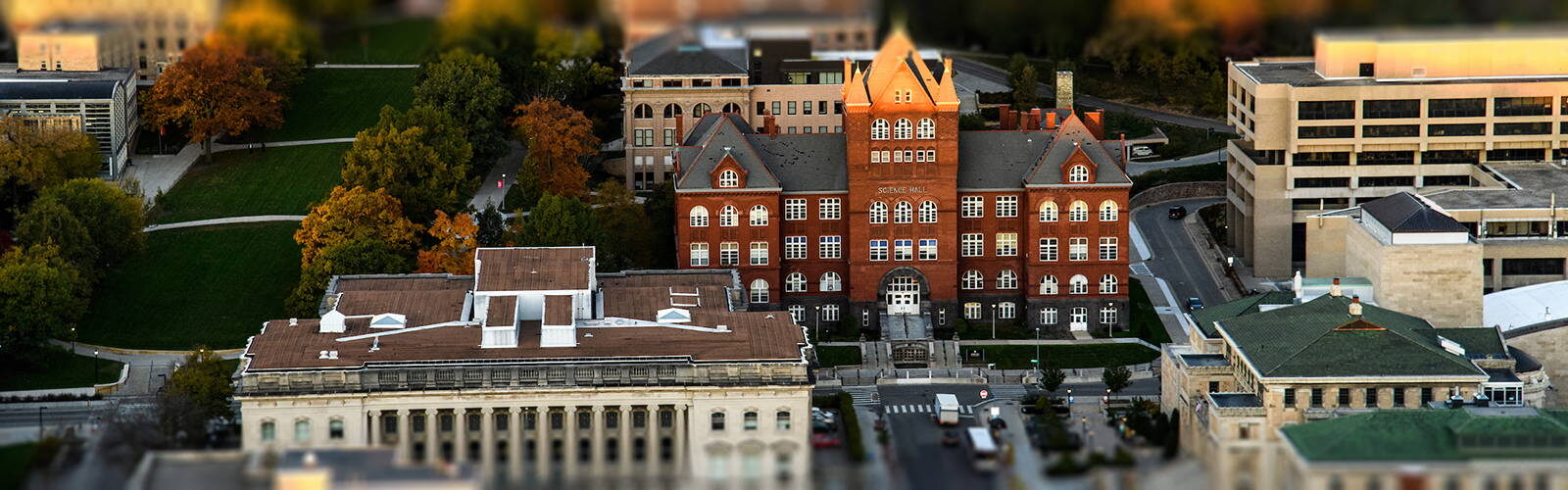 Aerial view of Science Hall at sunset with fall foliage in the background